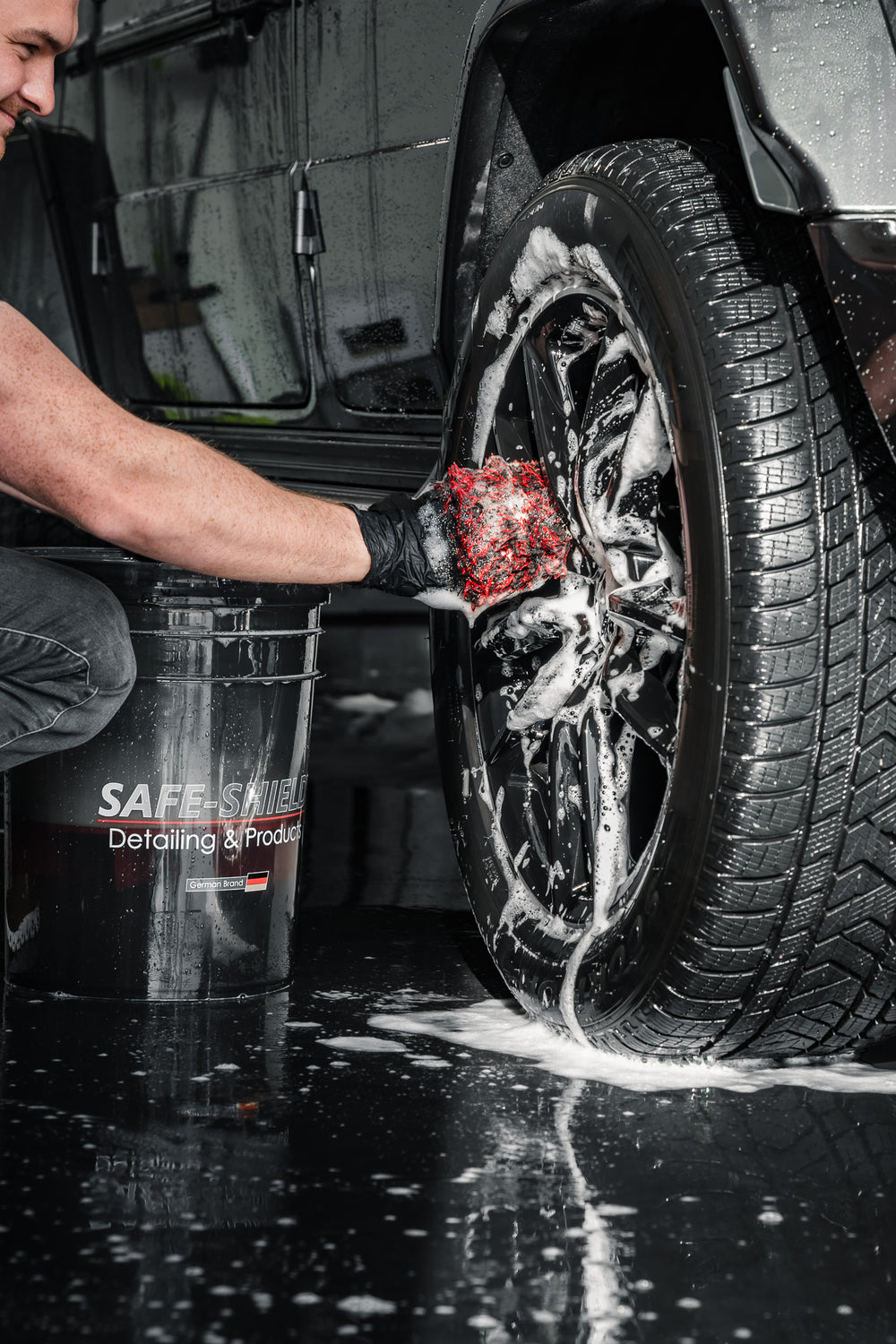 Black and red microfibre Wheel Mitt hand washing a foamed wheel