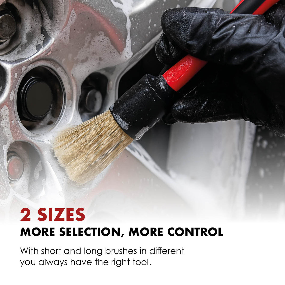 Natural-bristle detailing brush cleaning an alloy wheel