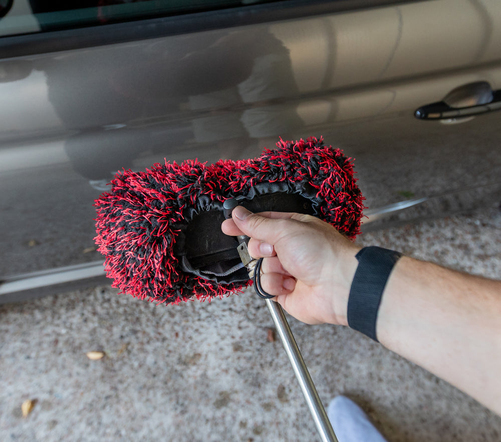 Black and red microfibre Brush Cover being secured around a wash brush head