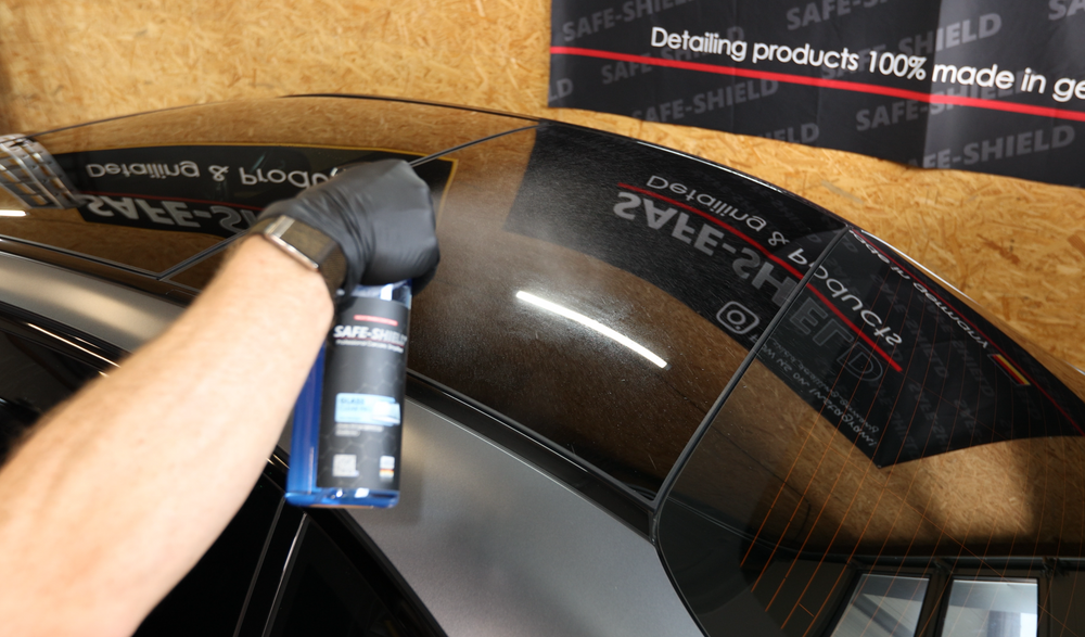 Glass Cleaner Pro being sprayed onto a vehicle's rear window